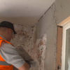 Thistle HardWall backing plaster being trowelled onto a wall
